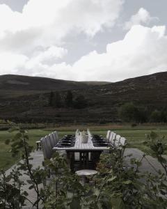 a picnic table with chairs and a table and a view at Gairnshiel lodge - Unique & exclusive lodge next to the castle in Ballater
