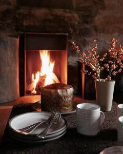 a table with a cake and a fireplace at Laggan Cottage - Charming home along River Gairn in Ballater