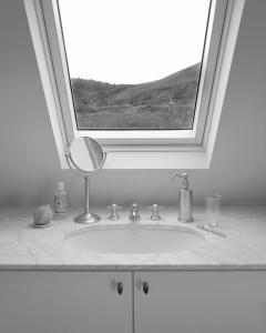 lavabo con espejo bajo una ventana en Laggan Cottage - Charming home along River Gairn, en Ballater