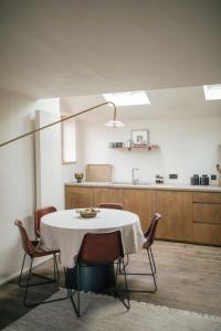 a dining room with a table and chairs and a kitchen at Inverenzie - Luxury farmhouse with mountain views 