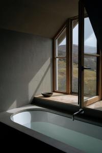 a bath tub in a room with a window at Inverenzie - Luxury farmhouse with mountain views 