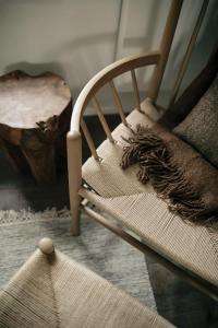 a wooden chair with a pillow and a wooden stump at Inverenzie - Luxury farmhouse with mountain views 