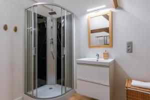 uma casa de banho com uma cabina de duche em vidro e um lavatório. em Beautiful apartment on top location in Ghent em Gent