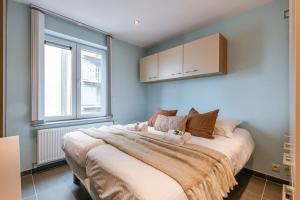 ein Schlafzimmer mit einem großen Bett mit braunen Kissen in der Unterkunft Spacious apartment with lateral sea view in Blankenberge