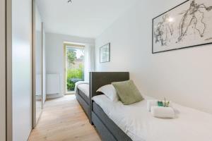 ein weißes Schlafzimmer mit einem Bett und einem Spiegel in der Unterkunft Modern 3 bedroom apartment in Blankenberge in Blankenberge