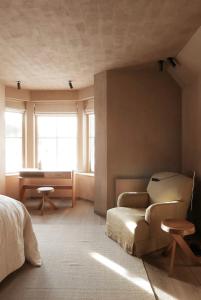 1 dormitorio con cama, sofá y escritorio en Gairnshiel lodge - Unique & exclusive lodge next to the castle en Ballater