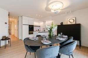 a dining room with a table and chairs and a kitchen at Modern apartment located on the square of De Panne in De Panne
