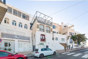 a white car parked in front of a building at AlmeriaSuite Roca 2 Mojacar in Mojácar