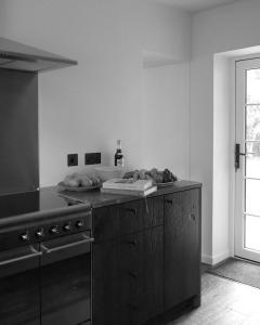 a black and white kitchen with a stove and a counter at Oldschool - Exclusive house surrounded by a dyke in Ballater
