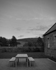 a picnic table in front of a stone building at Oldschool - Exclusive house surrounded by a dyke in Ballater
