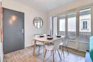 una sala da pranzo con tavolo, sedie e finestra di Atlas - Superbe logement plein centre - Terrasse a Nîmes