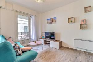 un soggiorno con divano blu e TV di Atlas - Superbe logement plein centre - Terrasse a Nîmes