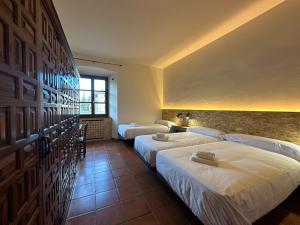 a hotel room with two beds and a window at Albergue Real Fabrica de Ezcaray in Ezcaray