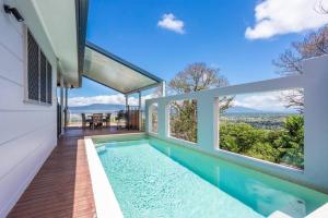 una piscina en una casa con ventanas en On the very top of Cairns - Luxurious Entertainer, en Bayview Heights