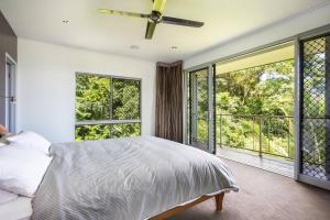 1 dormitorio con 1 cama y ventanas grandes en On the very top of Cairns - Luxurious Entertainer, en Bayview Heights