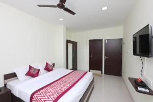 een slaapkamer met een bed en een flatscreen-tv bij Perfect Stay Near Meenambakkam Metro Station in Chennai