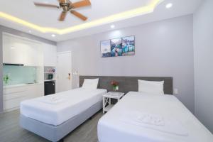 twee bedden in een kamer met witte muren en een plafond bij BELLA HOTEL PHU QUOC -Sunset Town, Địa Trung Hải- BIG PROMOTION 2024 in Phu Quoc