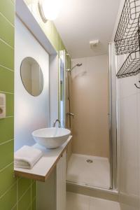 ein Bad mit einem Waschbecken und einer Dusche in der Unterkunft Characterful apartment for two in central Ghent in Gent