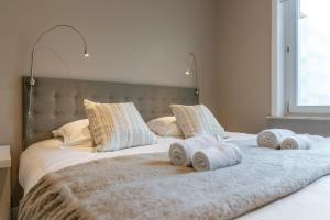 a large bed with towels on top of it at Huswell - Modern apartment in heart of Knokke with terrace in Knokke-Heist