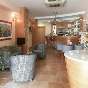 a room with chairs and a kitchen and a bar at Hotel le 3 lanterne in Marina di Sibari