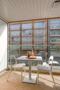a patio with a table and chairs and a building at Huswell - Apartment for 4 near the coast and central Knokke in Knokke-Heist