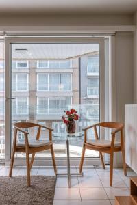 a table and two chairs in a room with a window at Huswell - Apartment for 4 near the coast and central Knokke in Knokke-Heist