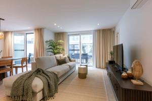 - un salon avec un canapé et une télévision dans l'établissement Cozy ground-floor apartment with spacious terrace, à Middelkerke