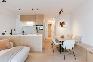 ein Wohnzimmer und eine Küche mit einem Tisch und Stühlen in der Unterkunft Huswell - Trendy apartment on top location in Knokke for 7 in Knokke-Heist