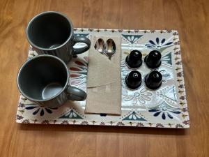 ein Tablett mit zwei Tassen und Löffeln auf einem Tisch in der Unterkunft Albergue Real Fabrica de Ezcaray in Ezcaray