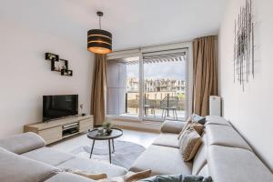 a living room with a couch and a tv at Bright duplexapartment in Ostend