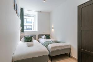 a bedroom with two beds and a window at Bright duplexapartment in Ostend