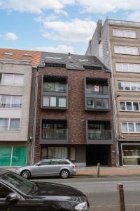 a car parked in front of a brick building at Bright duplexapartment in Ostend