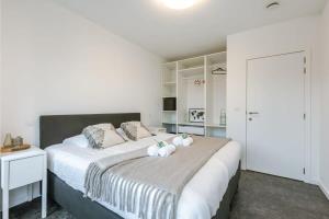 een slaapkamer met een groot bed met twee knuffels erop bij Spacious apartment in Kortrijk in Kortrijk