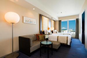 那覇市にあるリーガロイヤルグラン沖縄のベッドとソファ付きのホテルルーム