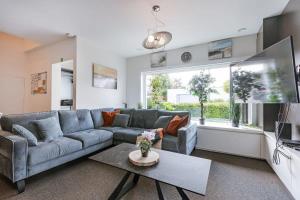 a living room with a blue couch and a table at Spacious house with garden and parking in Blankenberge