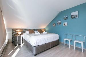 una camera da letto con un grande letto con pareti blu di Spacious house with garden and parking a Blankenberge