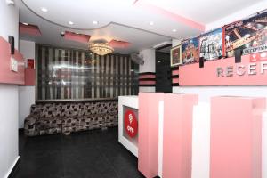 a restaurant with pink and white walls and a reception desk at Capital O Hotel Orchid Inn in Kankhal