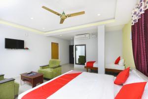 a bedroom with a bed and a tv and a chair at Hotel Sai Golden Rooms in Tirupati