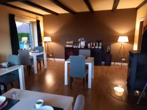 uma sala de jantar com mesas e cadeiras e uma sala com televisão em Bed & Breakfast Rheiderland em Ditzumerverlaat
