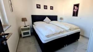 1 dormitorio con 1 cama grande con sábanas blancas en Fewo Ferrara en Abensberg