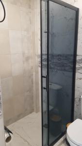 um chuveiro com uma porta de vidro na casa de banho em Къща за гости Ани em Černomorec