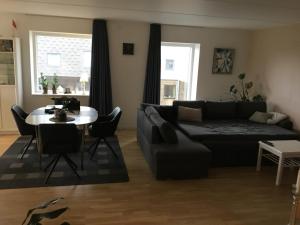 uma sala de estar com um sofá e uma mesa em Stor lejlighed tæt på Århus C. Stor tagterrasse em Aarhus