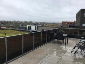 a balcony with chairs and a table on a building at Stor lejlighed tæt på Århus C. Stor tagterrasse in Aarhus