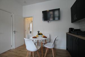 a kitchen with a white table and white chairs at Superb One Bedroom Apartment in Dundee in Dundee +4 photos