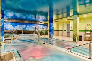 a large swimming pool in a building with a hot tub at Silken Spa La Hacienda De Don Juan in Llanes
