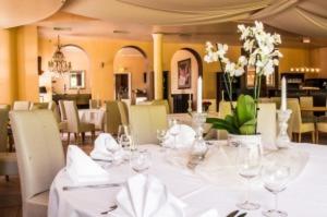 a dining room with a white table with glasses and flowers at Hotel Grüner Jäger in Jesteburg