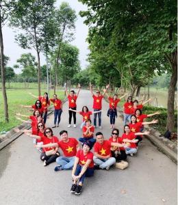 a group of people in red shirts posing for a picture at Resort Xanh Villa 5 Stars in Nam Giao