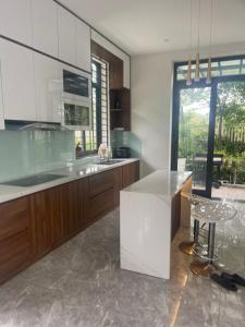 duża kuchnia z blatem i krzesłem w nim w obiekcie Resort Xanh Villa 5 Stars w mieście Nam Giao