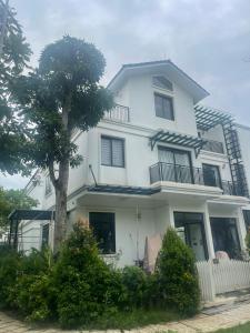Biały dom z drzewem przed nim w obiekcie Resort Xanh Villa 5 Stars w mieście Nam Giao