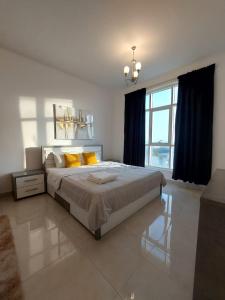 a large bedroom with a large bed with yellow pillows at EK Homes in Ras al Khaimah